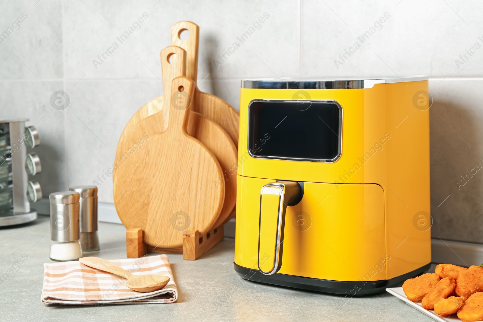 Photo of Air fryer and cooked chicken nuggets on counter in kitchen