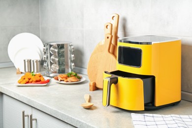 Photo of Air fryer and cooked chicken on counter in kitchen