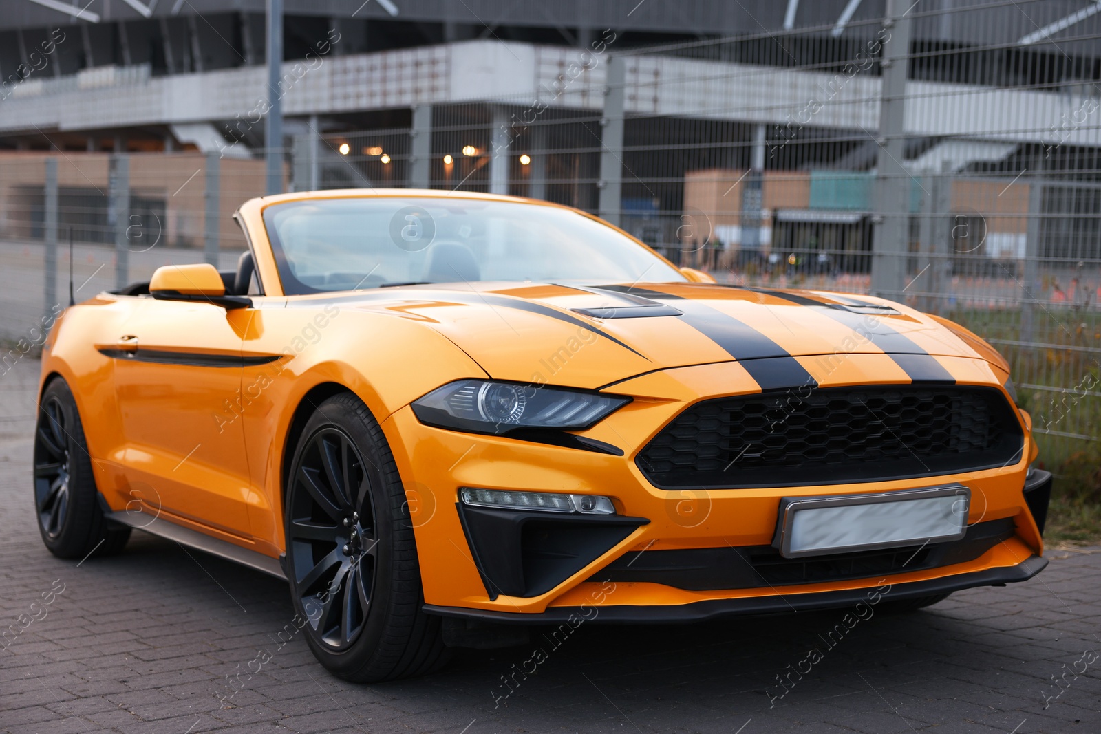 Photo of Modern cabriolet parked on stone pavement outdoors, closeup