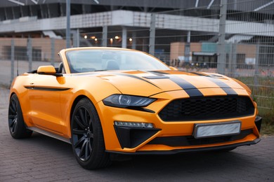 Photo of Modern cabriolet parked on stone pavement outdoors, closeup