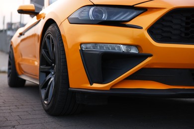 Photo of Modern cabriolet parked on stone pavement outdoors, closeup