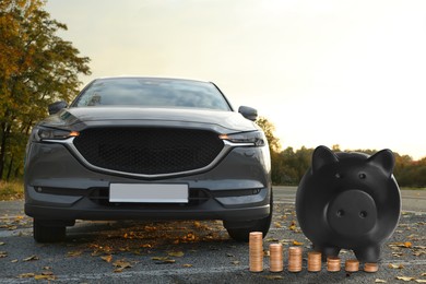 Image of Save money for car. Black piggy bank and coins near automobile outdoors
