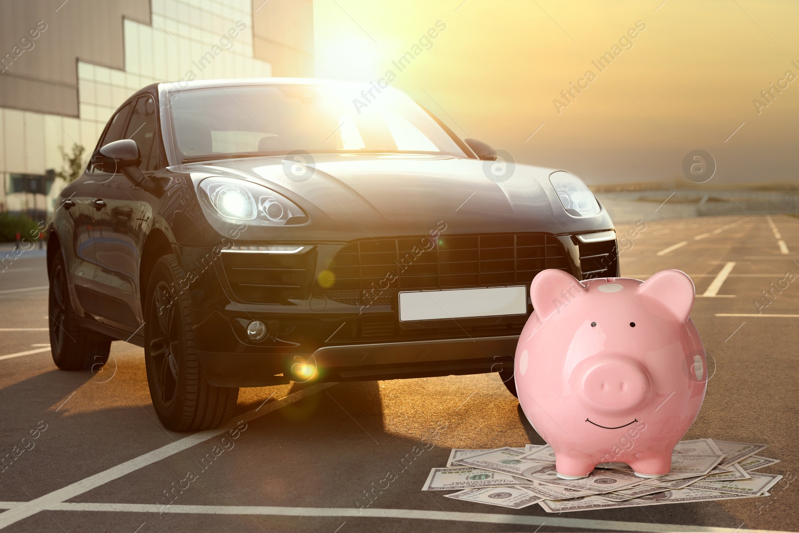 Image of Save money for car. Pink piggy bank and dollars near automobile outdoors