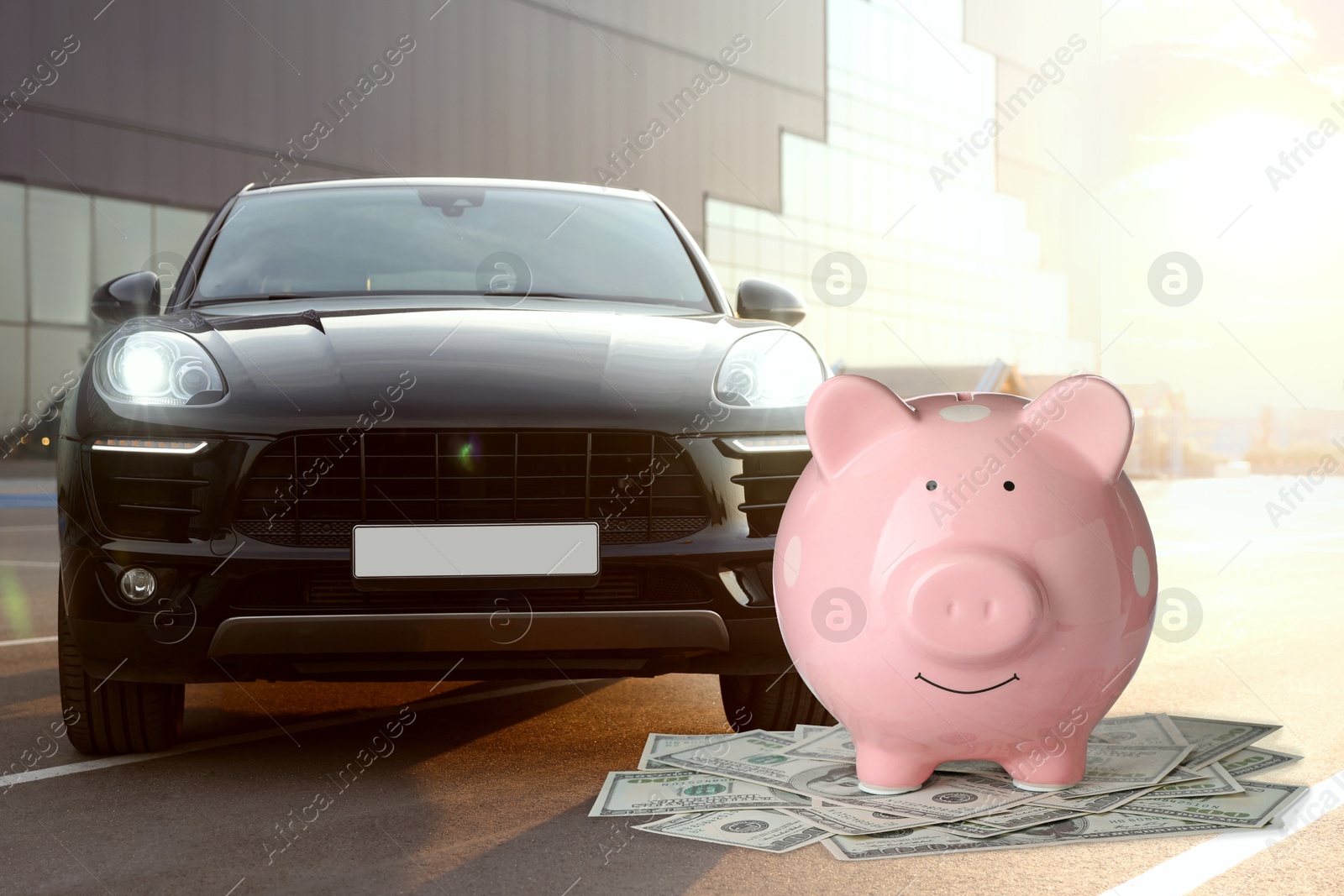 Image of Save money for car. Pink piggy bank and dollars near automobile outdoors