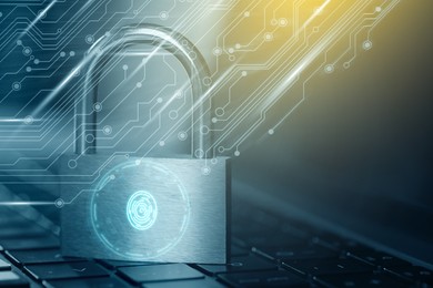 Image of Padlock with digital fingerprint scan on laptop, color toned. Circuit board pattern. Cyber security