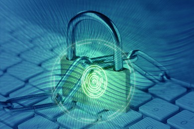 Image of Padlock with digital fingerprint scan and chain on laptop, toned in blue. Cyber security