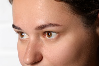 Photo of Woman with beautiful eyes on light background, closeup
