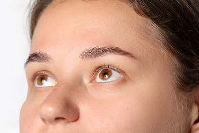 Photo of Woman with beautiful eyes on light background, closeup