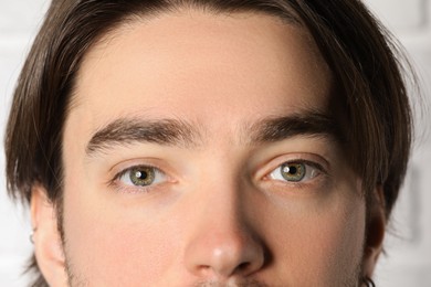 Photo of Man with beautiful eyes on light background, closeup