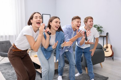 Photo of Group of friends singing karaoke at home