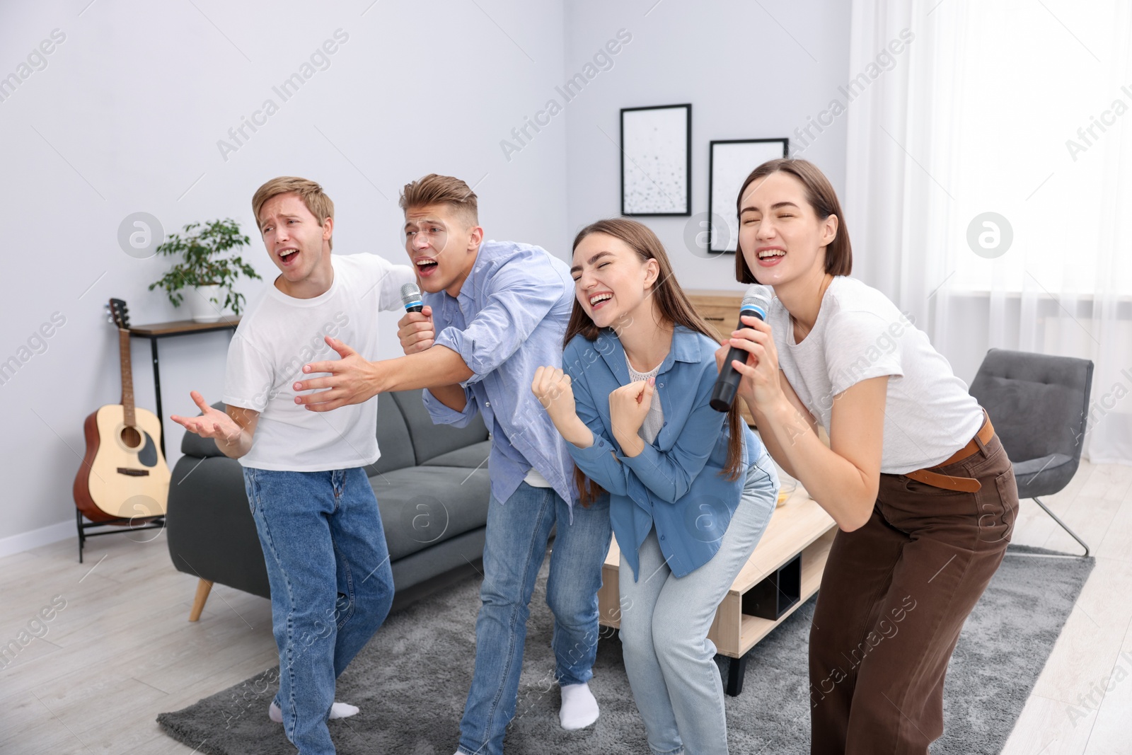 Photo of Group of friends singing karaoke at home