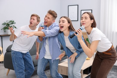 Photo of Group of friends singing karaoke at home