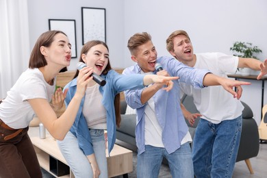 Photo of Group of friends singing karaoke at home