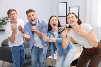 Photo of Group of friends singing karaoke at home