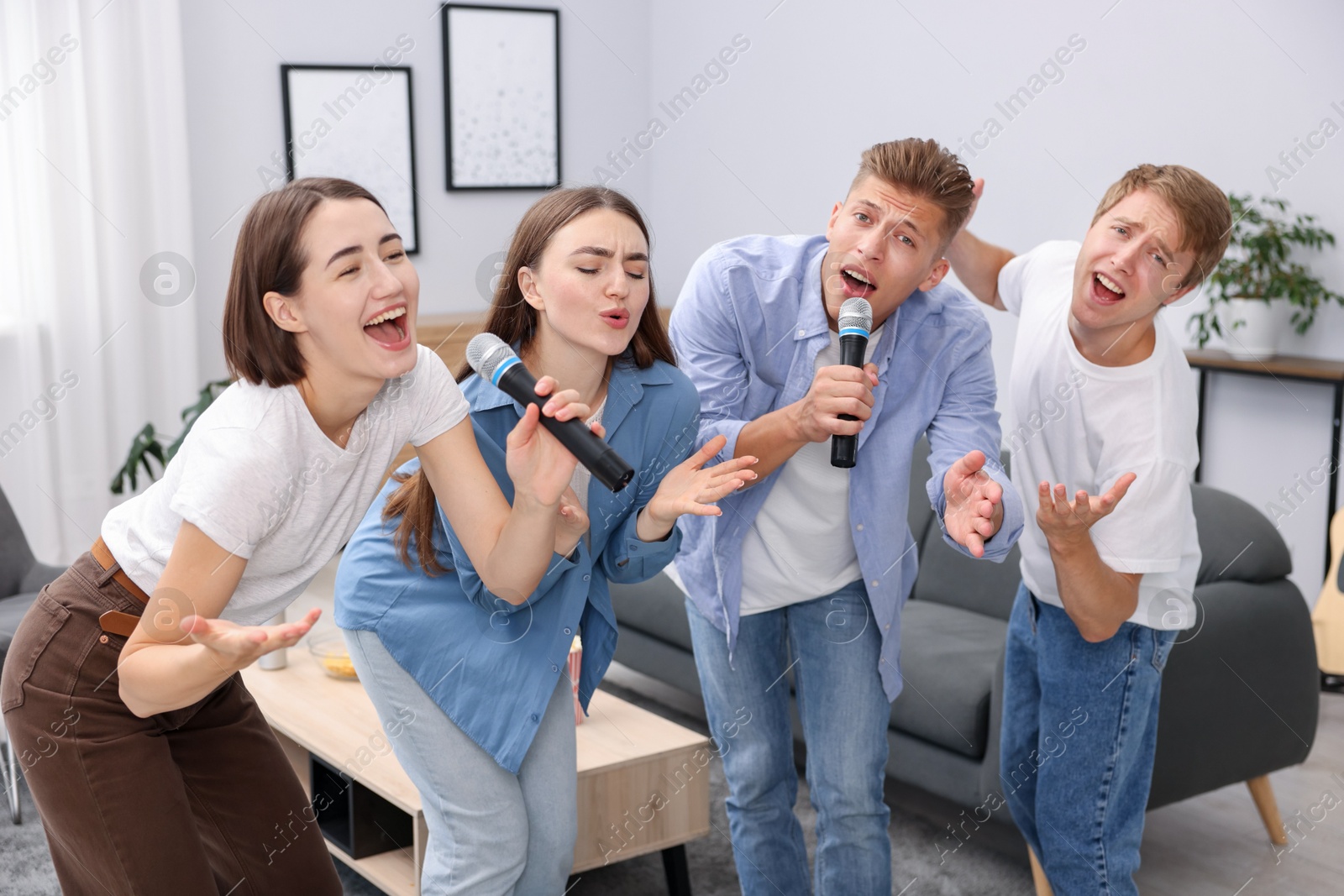 Photo of Group of friends singing karaoke at home