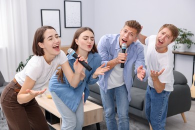 Photo of Group of friends singing karaoke at home