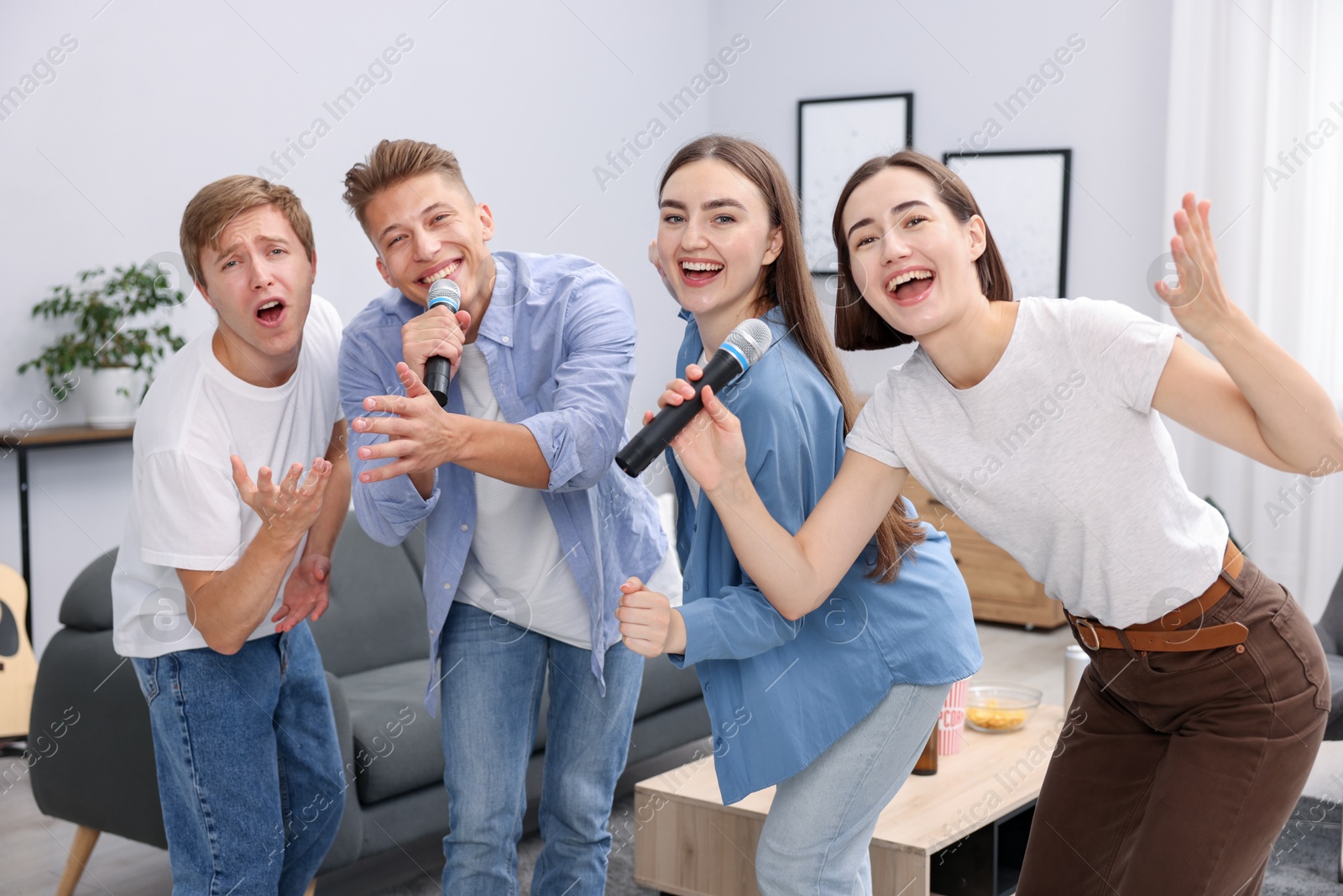 Photo of Group of friends singing karaoke at home