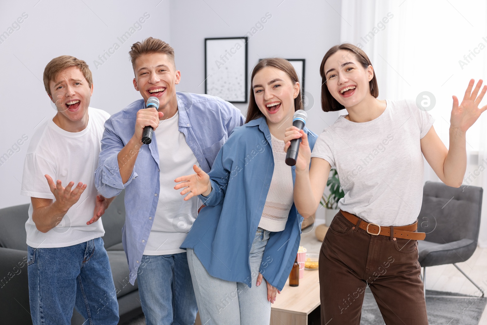 Photo of Group of friends singing karaoke at home