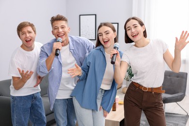 Photo of Group of friends singing karaoke at home