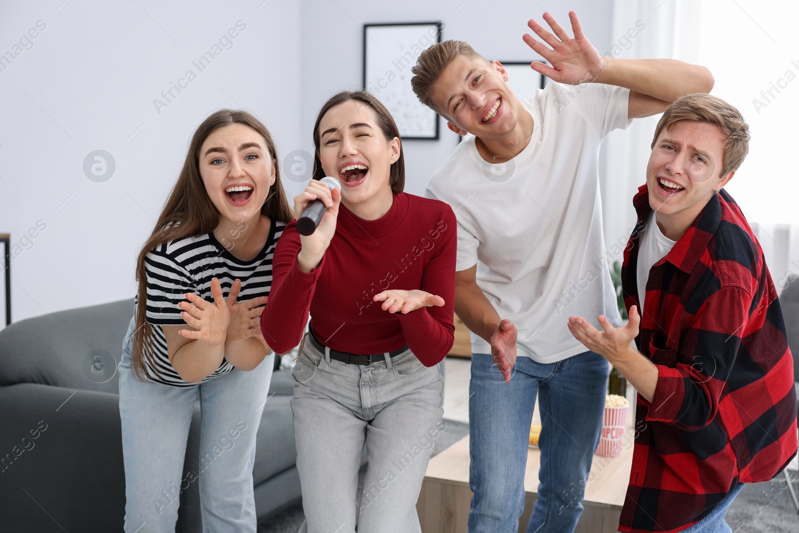 Photo of Group of friends singing karaoke at home