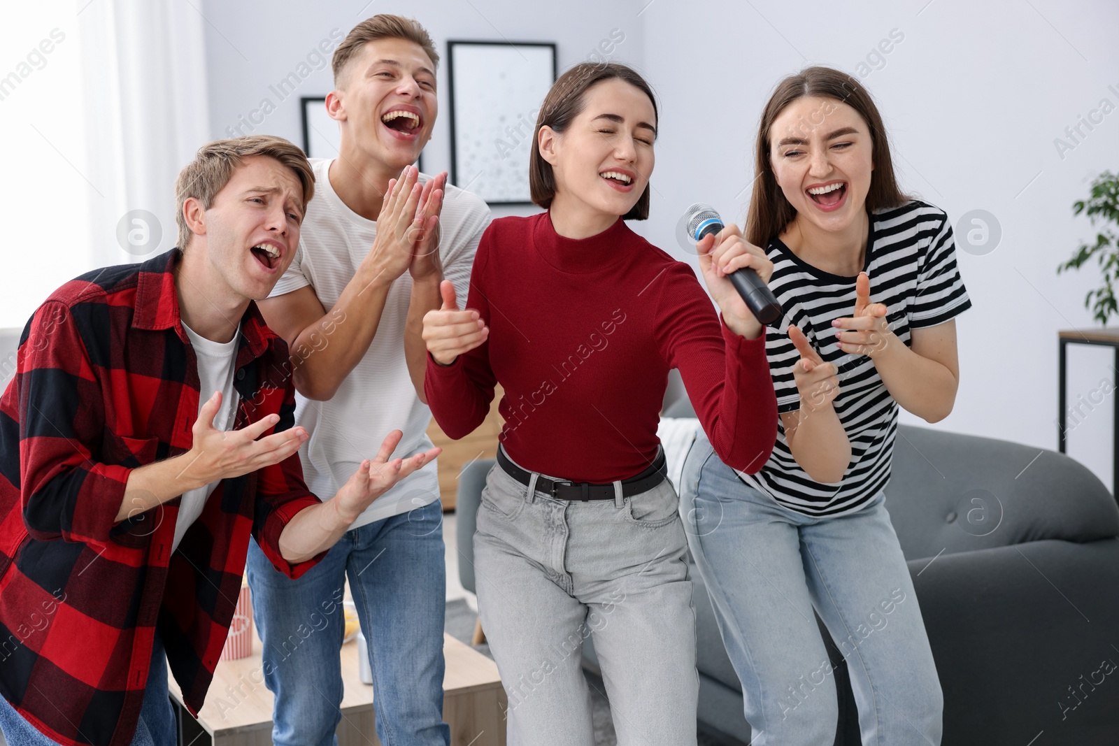 Photo of Group of friends singing karaoke at home