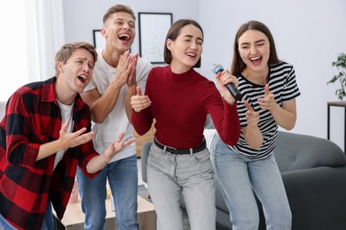 Photo of Group of friends singing karaoke at home