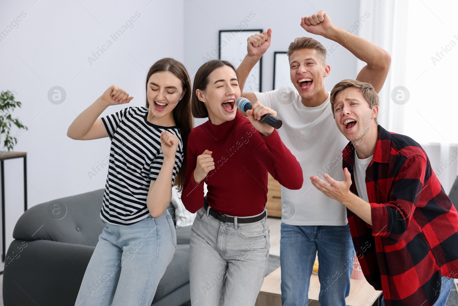 Photo of Group of friends singing karaoke at home