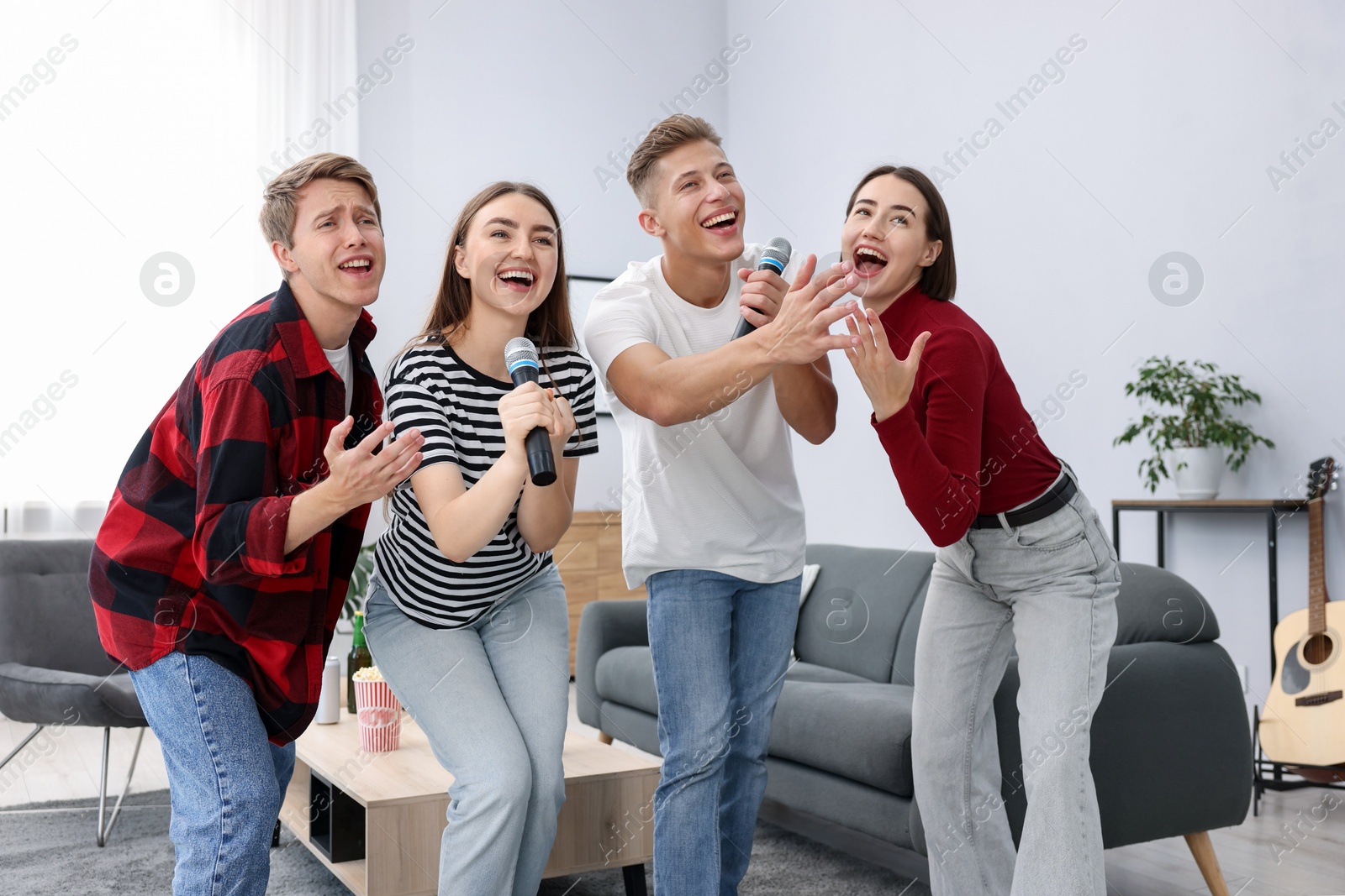Photo of Group of friends singing karaoke at home