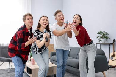 Photo of Group of friends singing karaoke at home