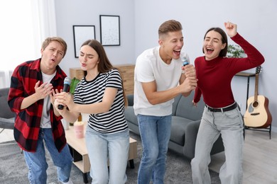 Photo of Group of friends singing karaoke at home