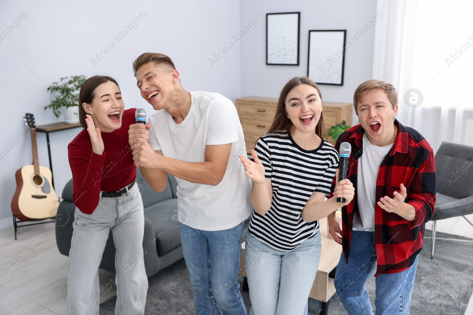Photo of Group of friends singing karaoke at home