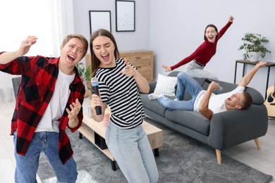 Photo of Group of friends singing karaoke at home