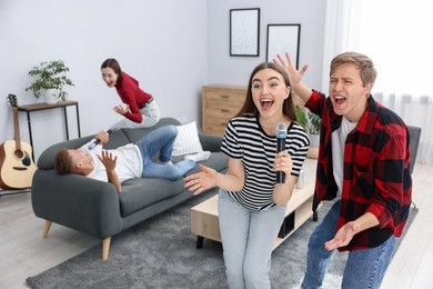 Photo of Group of friends singing karaoke at home