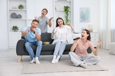 Photo of Group of friends singing karaoke at home