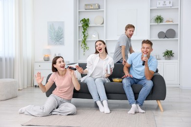 Photo of Group of friends singing karaoke at home