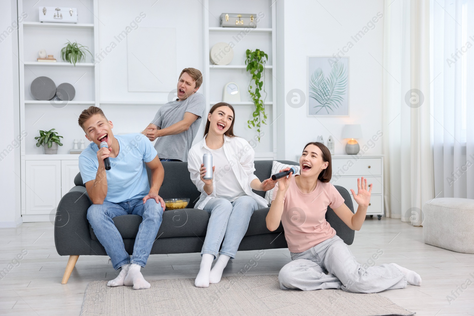 Photo of Group of friends singing karaoke at home