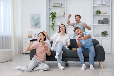 Photo of Group of friends singing karaoke at home
