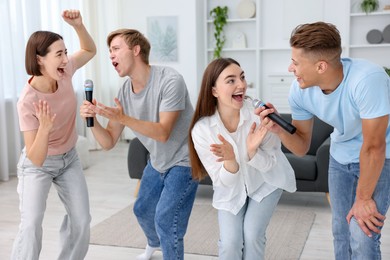Photo of Group of friends singing karaoke at home