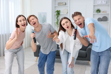Photo of Group of friends singing karaoke at home