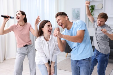 Photo of Group of friends singing karaoke at home