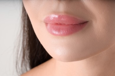 Photo of Woman with beautiful lips on light grey background, macro view