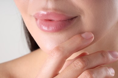 Photo of Woman with beautiful lips on light grey background, macro view