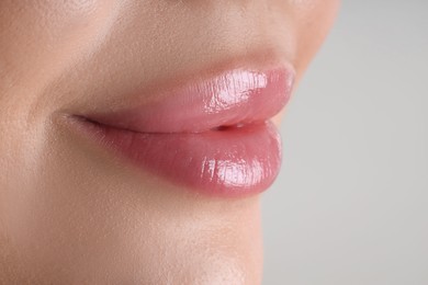 Photo of Woman with beautiful lips on light grey background, macro view. Space for text