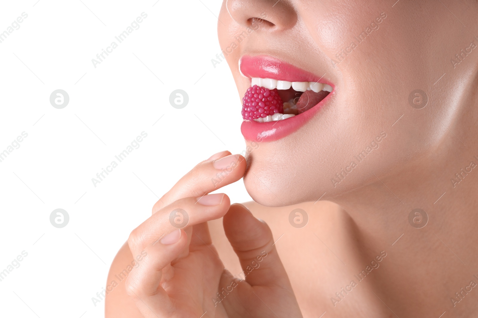 Photo of Woman with beautiful pink lipstick on her lips and raspberry candy against white background, closeup