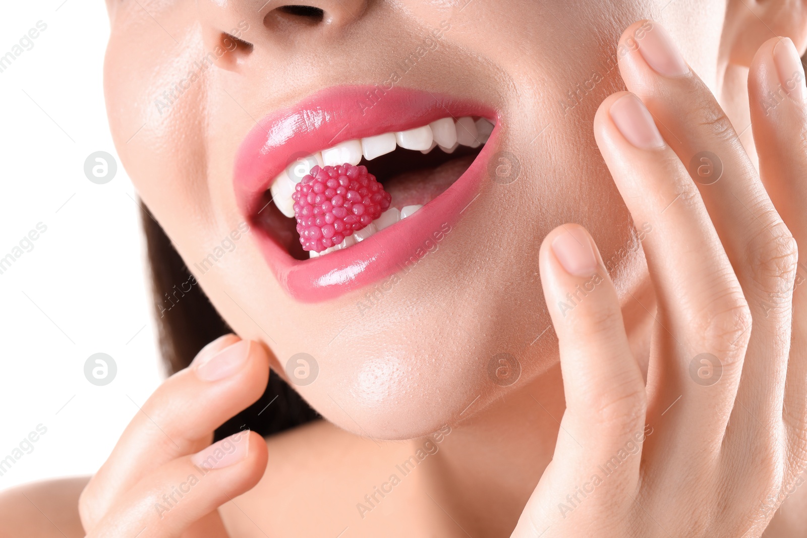 Photo of Woman with beautiful pink lipstick on her lips and raspberry candy against white background, closeup