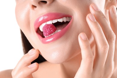 Photo of Woman with beautiful pink lipstick on her lips and raspberry candy against white background, closeup