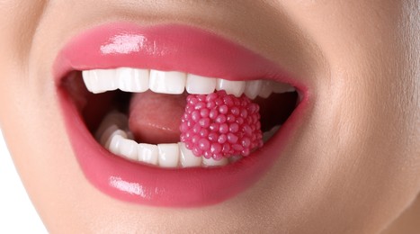 Photo of Woman with beautiful pink lipstick on her lips and raspberry candy against white background, closeup