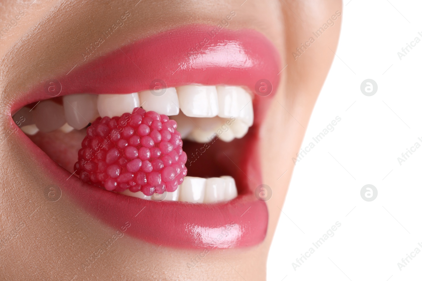 Photo of Woman with beautiful pink lipstick on her lips and raspberry candy against white background, closeup