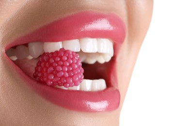 Photo of Woman with beautiful pink lipstick on her lips and raspberry candy against white background, closeup