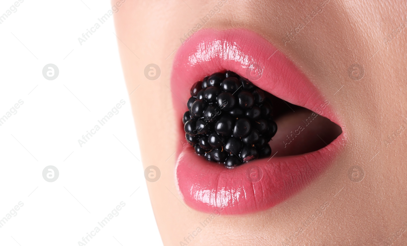Photo of Woman with beautiful pink lipstick on her lips and blackberry against white background, closeup